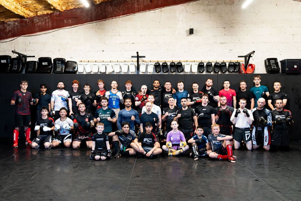 Adults and children of the Iron Fight Club Worcester team together on the mats